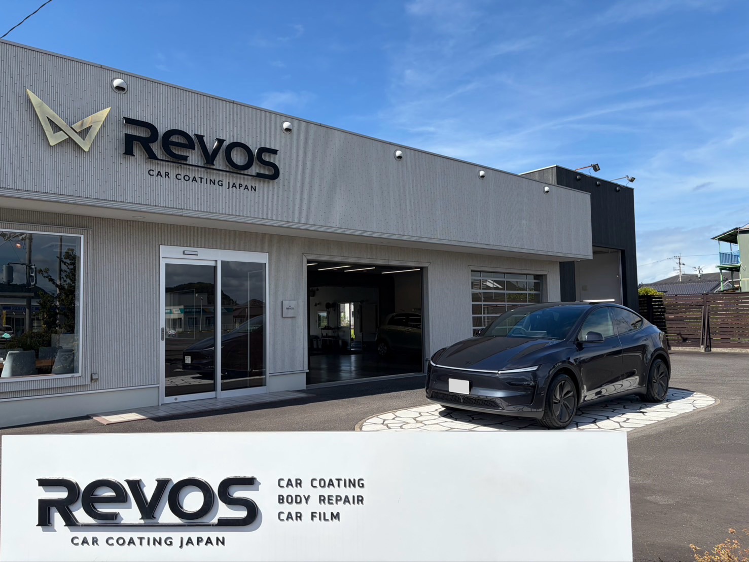 RevoSの店舗と看板の前に並ぶ施術後のテスラ モデルY