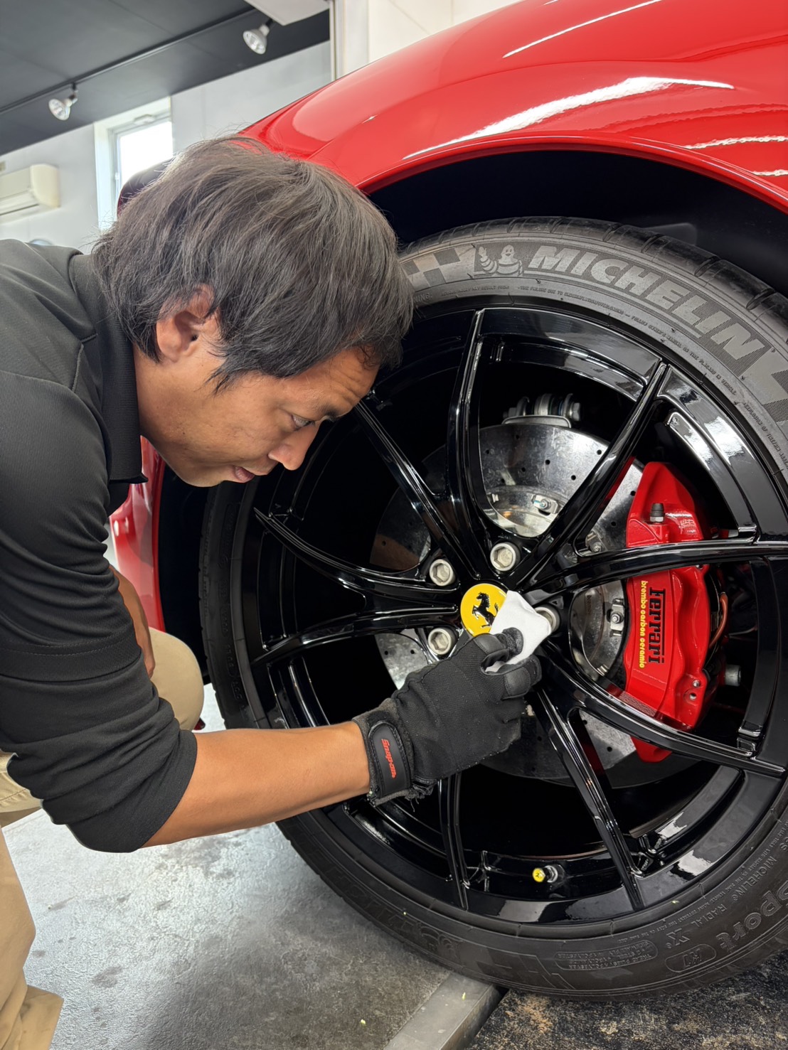 フェラーリ458様のホイールに手をかけるRevoSマイスター
