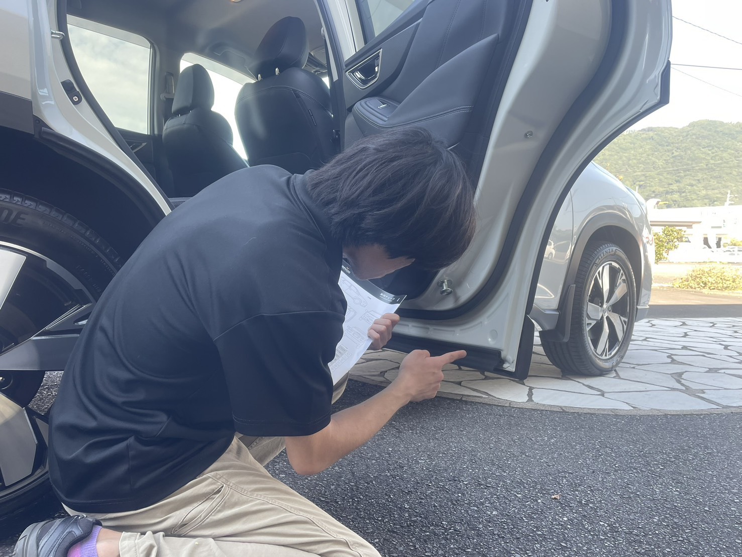 ドアを開けて下部まで仕上がりを確認するスタッフ