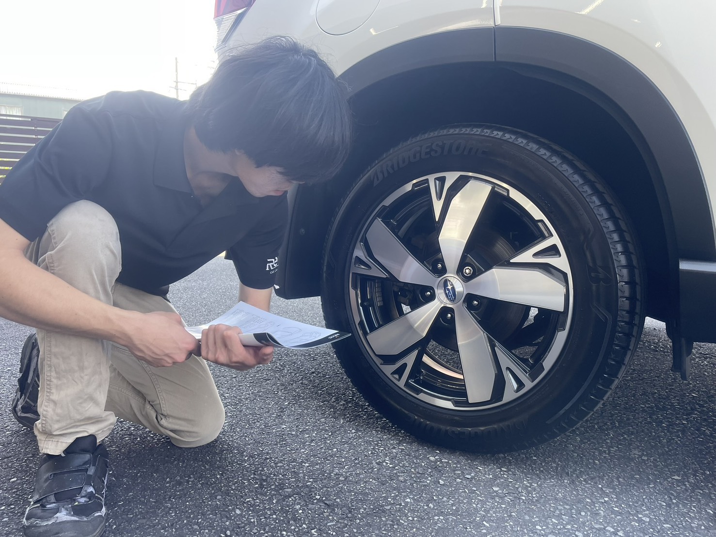 フォレスター様のタイヤとホイールを確認するスタッフ
