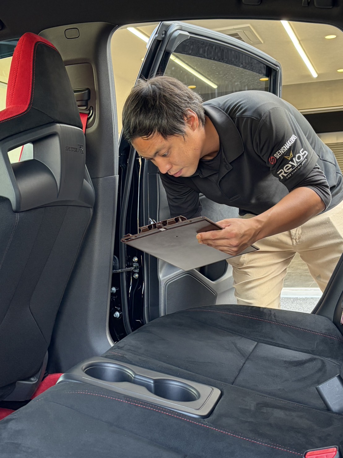 車内からドア周りの仕上がりを確認するスタッフ
